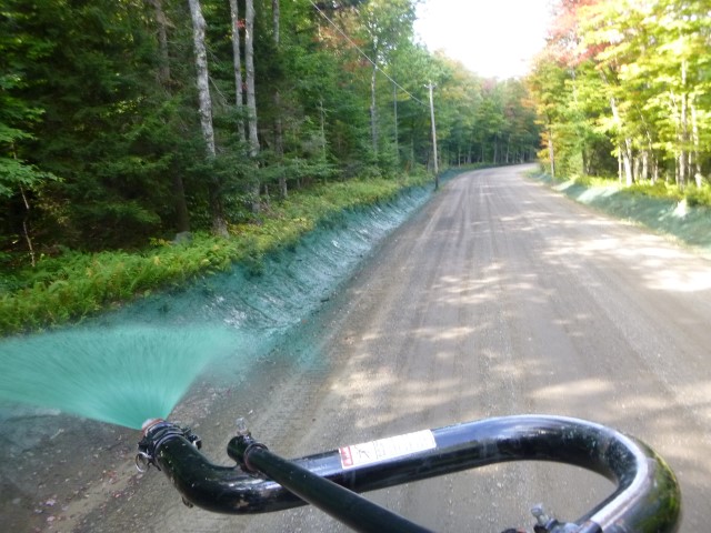 Hydroseeding a drainage ditch from the back of a truck