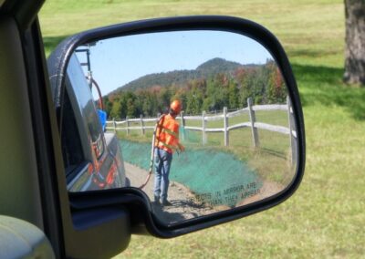 Hamilton County Soil and Water Conservation District employee seen hydroseeding in a truck mirror